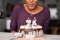 African woman blowing birthday candles on cake Royalty Free Stock Photo