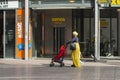 An African woman carrying a baby carriage