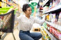 African Woman Choosing Products Doing Grocery Shopping In Supermarket Royalty Free Stock Photo