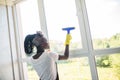 African woman cleaning glass with rubber window cleaner. Cleaning concept Royalty Free Stock Photo