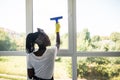 African woman cleaning glass with rubber window cleaner. Cleaning concept Royalty Free Stock Photo