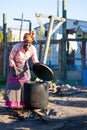 African Woman cook food in Big black pot. Royalty Free Stock Photo