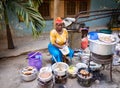 African woman cooking traditional food on street