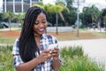 African woman with dreadlocks sending message with phone Royalty Free Stock Photo