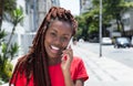 African woman with dreadlocks speaking at phone in the city Royalty Free Stock Photo