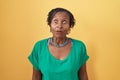 African woman with dreadlocks standing over yellow background afraid and shocked with surprise and amazed expression, fear and Royalty Free Stock Photo