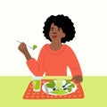 African woman eating green vegetables.