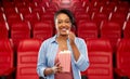 African woman eating popcorn at movie theater Royalty Free Stock Photo