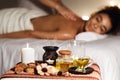 African woman enjoying aromatherapy massage in luxury spa