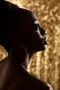 African Woman Face Profile Black Silhouette with Large Golden Rings Earrings. Dark Skinned Beauty Model with Gold Jewelry Royalty Free Stock Photo