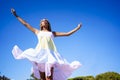 African woman flying her dress in the wind on a wooden road on the beach. Royalty Free Stock Photo