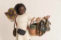 African woman holding a colourful selection of multicoloured handbags from Africa