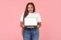 African Woman Holding Laptop Showing Blank Screen Over Pink Background Royalty Free Stock Photo