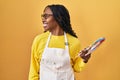 African woman holding painter palette looking to side, relax profile pose with natural face and confident smile