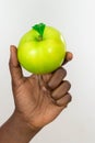 African woman holding up delicious green apple isolated on a white background