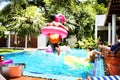 African woman jumping to the pool with inflatable tube Royalty Free Stock Photo