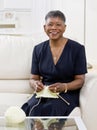 African woman knitting on sofa at home Royalty Free Stock Photo
