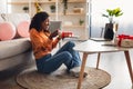 African Woman At Laptop Opening Birthday Gift At Home, Side-View