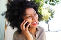 African woman laughing with mobile phone outside Royalty Free Stock Photo