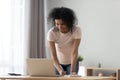 African woman looking at computer writing down useful important information