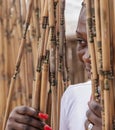 African woman looks out through a bamboo drapery