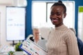 African woman manager looking at camera smiling, holding clipboard Royalty Free Stock Photo