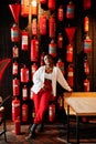 African woman posed against wall with old extinguisher. Royalty Free Stock Photo