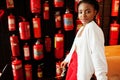 African woman posed against wall with old extinguisher. Royalty Free Stock Photo