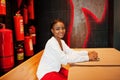 African woman posed against wall with old extinguisher. Royalty Free Stock Photo