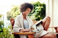 African woman, reading and backyard patio with book and coffee feeling relax and happy. Happiness, black female person Royalty Free Stock Photo