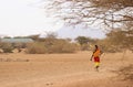 African woman from the Samburu tribe related to the Masai tribe in national costume walks on savanna