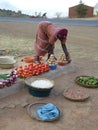 African woman selling food on a dusty roadside
