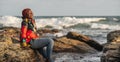 African woman sitting on the beach cliffs at sunset