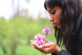 African woman smells the aroma of beautiful flowers in her hands Royalty Free Stock Photo