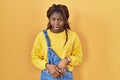 African woman standing over yellow background afraid and shocked with surprise and amazed expression, fear and excited face Royalty Free Stock Photo