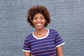 African woman in striped shirt smiling against gray wall Royalty Free Stock Photo