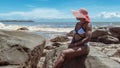 African woman with sunhat sitting on a rock Royalty Free Stock Photo