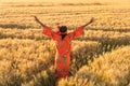African Woman In Traditional Clothes Arms Raised In Field Of Crops At Sunset Or Sunrise