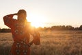 African woman in traditional clothes in a field of crops at suns