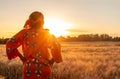 African woman in traditional clothes standing in a field of crops at sunset or sunrise Royalty Free Stock Photo