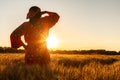 African woman in traditional clothes standing in a field of crops at sunset or sunrise Royalty Free Stock Photo