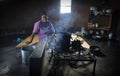 African woman traditional cooking and sitting besides cooking pot in Harare Zimbabwe