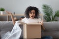 African woman unpack parcel feels angry see broken ordered goods Royalty Free Stock Photo