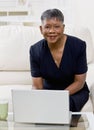 African woman using laptop on sofa at home Royalty Free Stock Photo