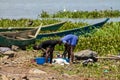 African woman wash clothes on the shore of Lake Victoria