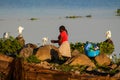 African woman wash dishes on the shore of Lake Victoria