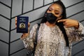 African woman wearing black face mask show Cape Verde passport in hand. Coronavirus in Africa country, border closure and