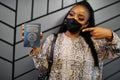 African woman wearing black face mask show Cameroon passport in hand. Coronavirus in Africa country, border closure and quarantine