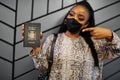 African woman wearing black face mask show Zambia passport in hand. Coronavirus in Africa country, border closure and quarantine,