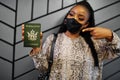 African woman wearing black face mask show Zimbabwe passport in hand. Coronavirus in Africa country, border closure and quarantine